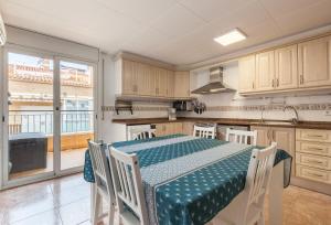 a kitchen with a table with chairs and a large window at Malgrat in Malgrat de Mar
