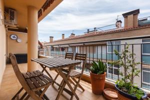 a balcony with a wooden table and chairs on a building at Malgrat in Malgrat de Mar