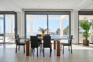 a dining room with a glass table and chairs at Villa Palacio Nazari in Málaga