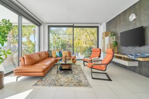 a living room with a leather couch and two chairs at Villa Palacio Nazari in Málaga