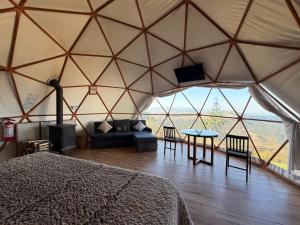 a bedroom in a yurt with a bed and a table at Glamping Las Nubes in Chignahuapan