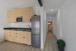 a kitchen with a stainless steel refrigerator and wooden cabinets at Casa Us in Arinaga
