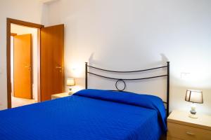a bedroom with a blue bed and two lamps at Terra in Follonica