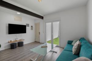 a living room with a blue couch and a tv at Casa Us in Arinaga