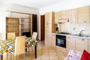 a kitchen with a table with chairs and a sink at Terra in Follonica