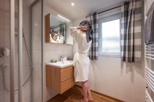 a woman is standing in front of a bathroom mirror at Apartment Eve in Söll