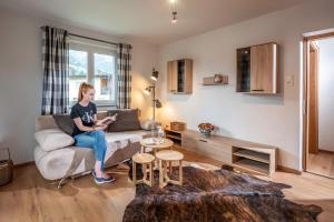 a woman sitting on a couch in a living room at Apartment Eve in Söll