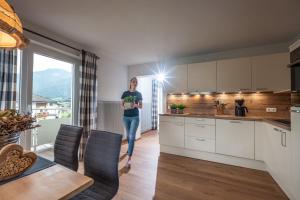 a woman standing in a kitchen with a plant at Apartment Eve in Söll +4 photos