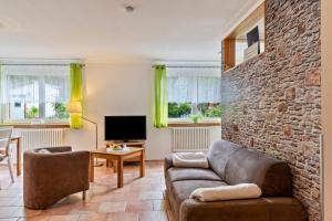a living room with a couch and a stone wall at im Oberdorf in Achern