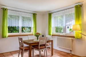 a dining room with green curtains and a wooden table and chairs at im Oberdorf in Achern +17 photos