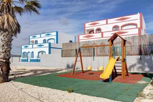 a playground with a slide in front of a building at Yasmim House in Sagres