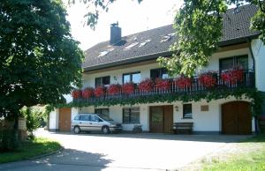 a house with a balcony with red flowers on it at Winzerhof Wörner in Durbach