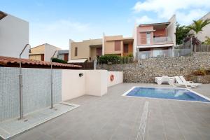 a backyard with a swimming pool and a house at La Quinta Adosado in Santa Úrsula