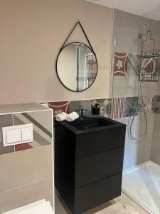 a bathroom with a black sink and a mirror at La Cure Vosgienne in Champdray