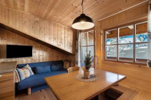 a living room with a blue couch and a table at Jelerhof in Gsies