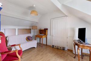 a living room with a bed and a desk and a tv at Chambre Terracotta in Tavant +13 photos