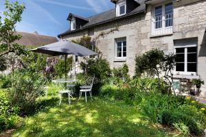 a table and chairs and an umbrella in a yard at Chambre Terracotta in Tavant