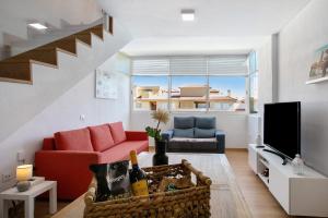 a living room with a couch and a tv at Oramas Beach House – Pool & Terrace in Puertito de Güímar