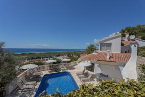 a villa with a swimming pool and views of the ocean at Villa Maitreya in Son Bou