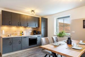 a kitchen and dining room with a wooden table at Ferienwohnungen Mayerhofer in Arnstorf +32 photos