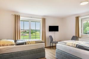 two beds in a room with a window at Ferienwohnungen Mayerhofer in Arnstorf