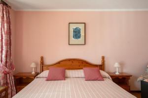 a bedroom with a bed with two pink pillows at Il Borgo - Aymavilles in Aymavilles
