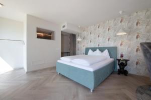 a bedroom with a blue bed and a wall at Villa Gargnano in Gargnano
