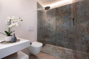 a bathroom with a toilet and a shower at Villa Gargnano in Gargnano +12 photos