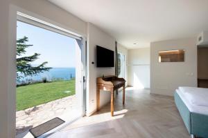 a bedroom with a large sliding glass door with a desk at Villa Gargnano in Gargnano
