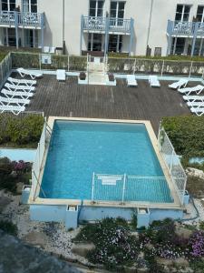 an empty swimming pool with chairs and a building at Appartement duplex vue mer in Audierne