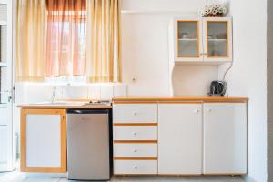 a kitchen with white cabinets and a dishwasher at Panorama Tilos Apt A in Tílos +3 photos