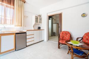 a kitchen with a table and a chair and a table and a tablektop at Panorama Tilos Apt A in Tílos