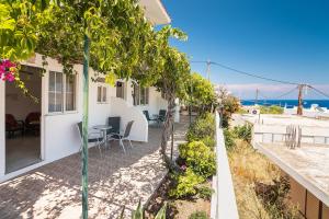 a house with a patio with a view of the ocean at Panorama Tilos Apt A in Tílos