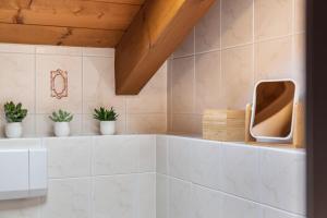 a bathroom with potted plants on a shelf at Alpblick Apartment Zugspitze in Garmisch-Partenkirchen +21 photos