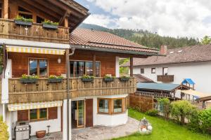 a house with a wooden facade with a balcony at Alpblick Apartment Zugspitze in Garmisch-Partenkirchen
