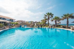 a large swimming pool with the ocean in the background at Mirage Arillas Studio Type B11 in Arillas +13 photos
