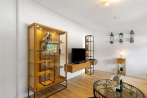 a living room with a tv and a glass table at Schwalbennest in Lennestadt