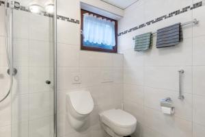 a bathroom with a toilet and a shower and a window at Schwalbennest in Lennestadt +18 photos