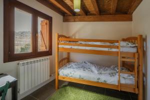 two bunk beds in a room with a window at Astial Ezquerra - Casa Rural in Ezquerra