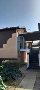 a stairway leading to a building with a blue railing at Charmant Studio Mezzanine in Biscarrosse +2 photos