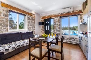 a kitchen and living room with a table and a couch at Superior Apartment A in Tsoukalades