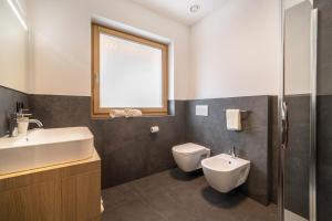 a bathroom with a sink and a toilet and a window at Apt Zirbe - Nockerhof in Andrian +20 photos