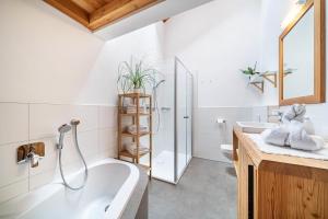 a bathroom with a tub and a toilet and a sink at Ferienhaus Larch Soge Apt Paula in Racines +18 photos