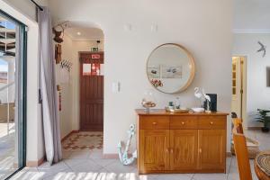 a bathroom with a mirror and a wooden dresser at Ria's Birds in Cabanas de Tavira +24 photos