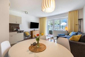 a living room with a table and a kitchen at Meerfamilie in Noer