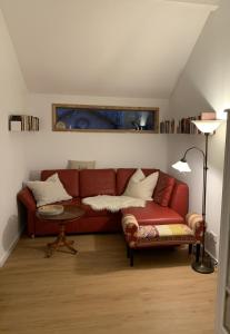 a living room with a red couch and a table at Das Sommerhaus in Zülow