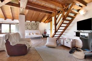 a living room with a staircase and a tv at Villa Adele in Gravedona