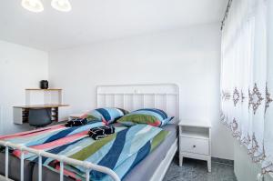 a bedroom with a bed with a white headboard at See Oase in Uhldingen-Mühlhofen
