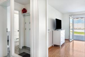 a white room with a tv and a mirror at See Oase in Uhldingen-Mühlhofen