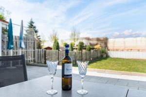 a bottle of wine and two wine glasses on a table at See Oase in Uhldingen-Mühlhofen